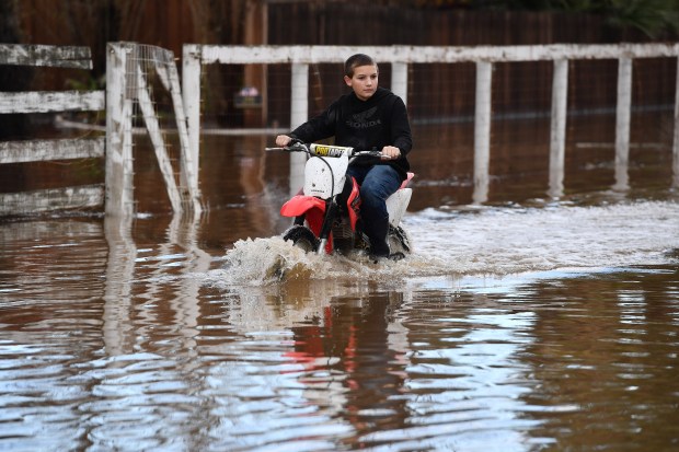 Devan Beard, age 13, of Brentwood, rides his off-road motorcycle around his flooded home on Bixler Road in Brentwood, Calif., on Monday, Jan. 15, 2023. (Jose Carlos Fajardo/Bay Area News Group)